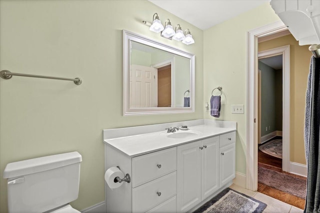 bathroom featuring toilet, wood finished floors, and vanity