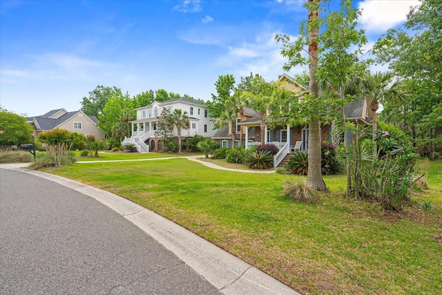 view of front of property with stairway, a porch, and a front yard