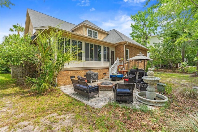 back of house featuring a gazebo, a patio area, a sunroom, brick siding, and a shingled roof