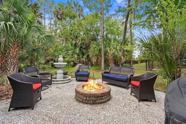 view of patio / terrace with fence and an outdoor living space with a fire pit