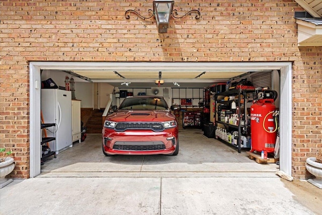 garage with freestanding refrigerator and a garage door opener