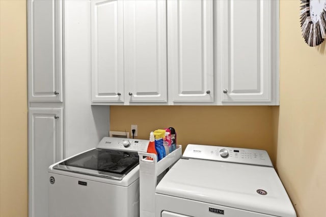 washroom featuring washer and clothes dryer and cabinet space