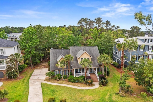 new england style home featuring covered porch and a front lawn