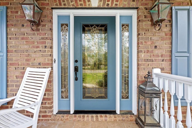 view of exterior entry featuring brick siding