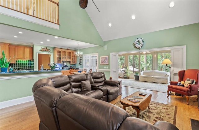 living area featuring high vaulted ceiling, a chandelier, light wood finished floors, ornamental molding, and recessed lighting