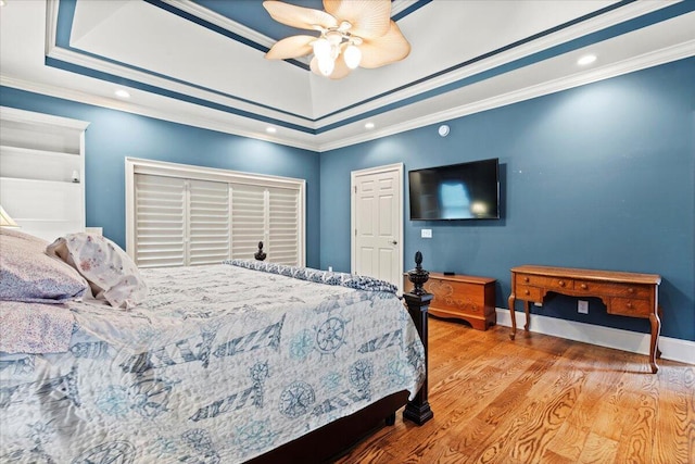 bedroom featuring wood finished floors, crown molding, recessed lighting, a ceiling fan, and baseboards