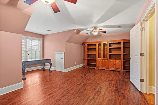 additional living space with a ceiling fan, baseboards, dark wood-type flooring, and vaulted ceiling