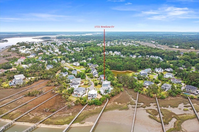 aerial view of property and surrounding area featuring nearby suburban area and a large body of water