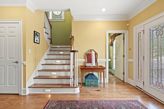 foyer featuring crown molding, stairs, wood finished floors, baseboards, and recessed lighting
