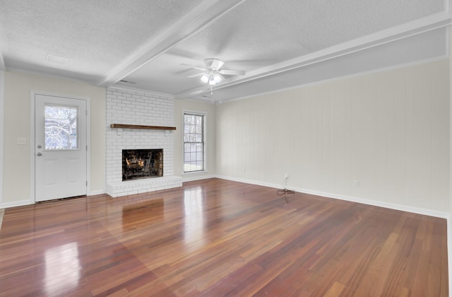 unfurnished living room with a ceiling fan, plenty of natural light, wood finished floors, and a textured ceiling