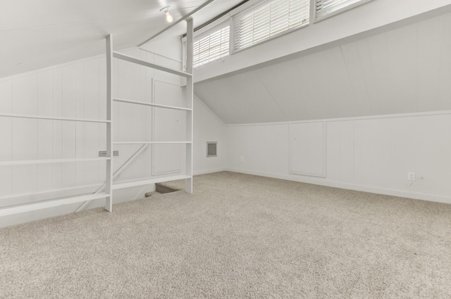 additional living space with visible vents, carpet floors, and lofted ceiling