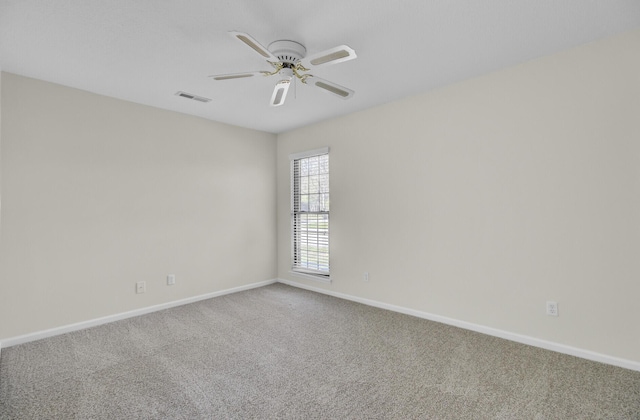 empty room featuring visible vents, carpet floors, baseboards, and a ceiling fan