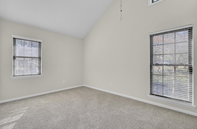 spare room featuring baseboards, carpet, and vaulted ceiling