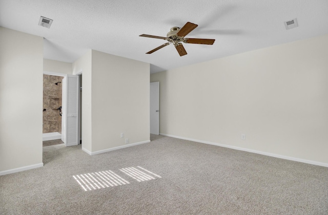 empty room with visible vents, carpet flooring, baseboards, and a ceiling fan