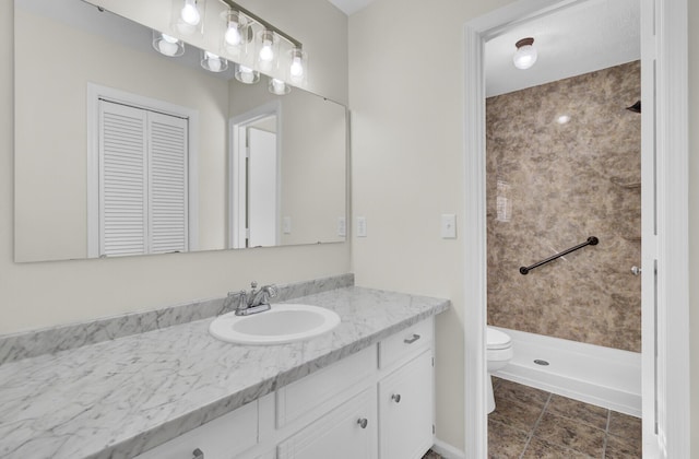 bathroom featuring a stall shower, toilet, and vanity