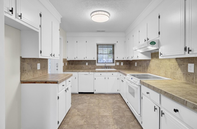 kitchen featuring under cabinet range hood, decorative backsplash, white cabinets, white appliances, and a sink