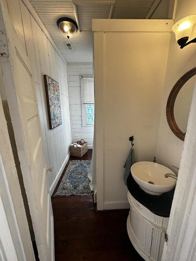 bathroom featuring wooden walls and wood-type flooring