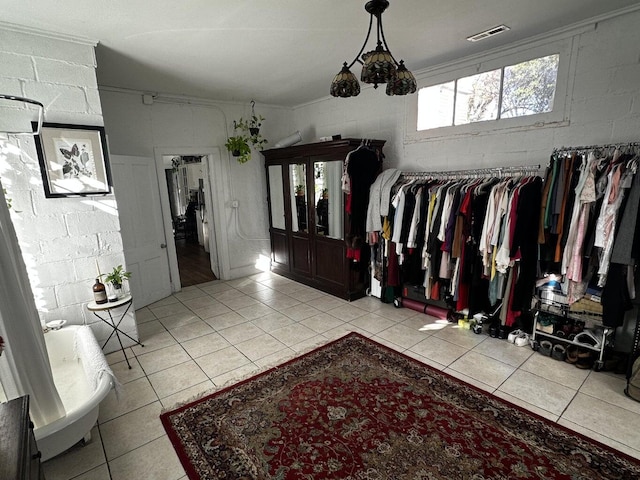 walk in closet featuring a chandelier and light tile patterned floors