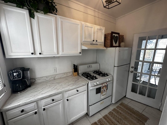 kitchen featuring light tile patterned flooring, light stone countertops, white cabinets, and white appliances