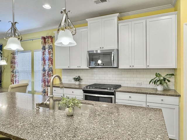 kitchen with white cabinetry, appliances with stainless steel finishes, decorative light fixtures, and decorative backsplash