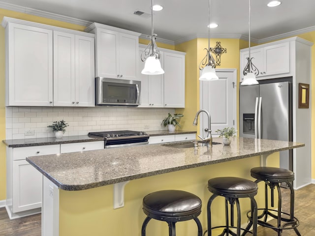 kitchen with dark wood-type flooring, sink, white cabinetry, an island with sink, and stainless steel appliances