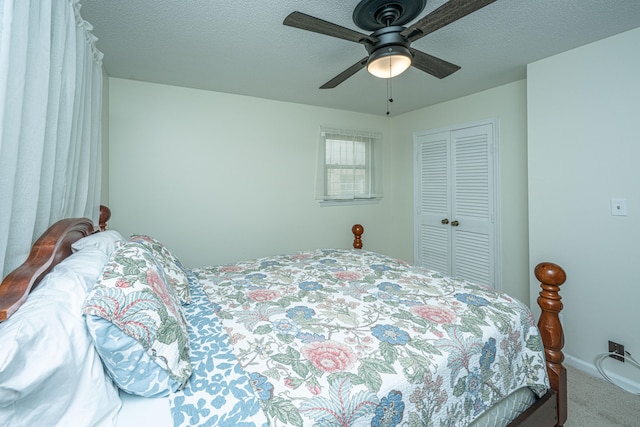 carpeted bedroom featuring a closet, ceiling fan, and a textured ceiling