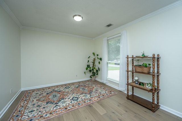 unfurnished room with light wood-type flooring and ornamental molding