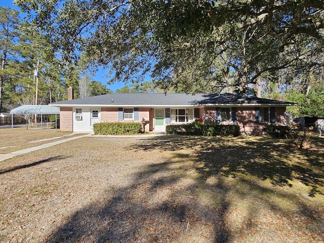 single story home featuring a front lawn and a carport