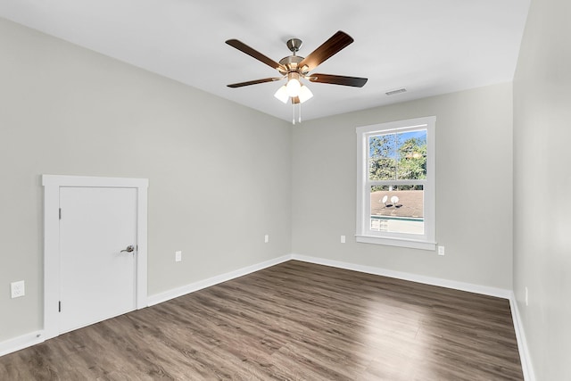 empty room with dark hardwood / wood-style flooring and ceiling fan