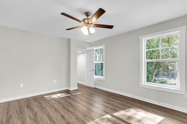 spare room with ceiling fan, a healthy amount of sunlight, and dark hardwood / wood-style flooring