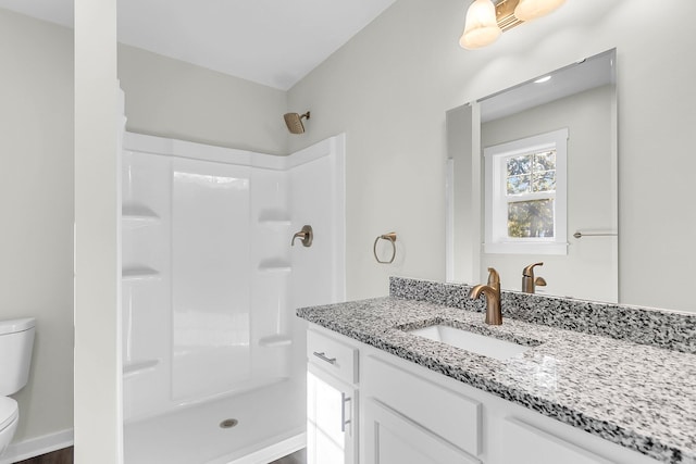 bathroom featuring vanity, toilet, and walk in shower