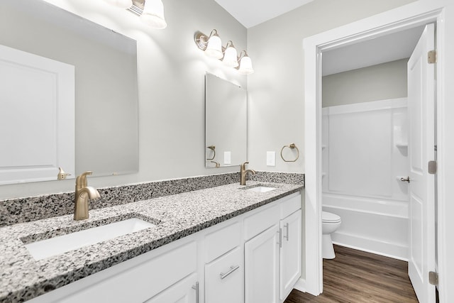 2711 Henry St, North Charleston, SC 29405 - bathroom featuring toilet, double vanity, wood finished floors, and shower / bathtub combination