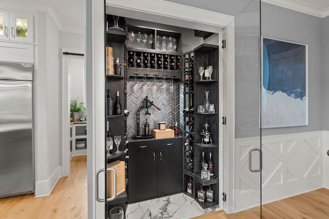 wine room featuring light hardwood / wood-style floors and crown molding