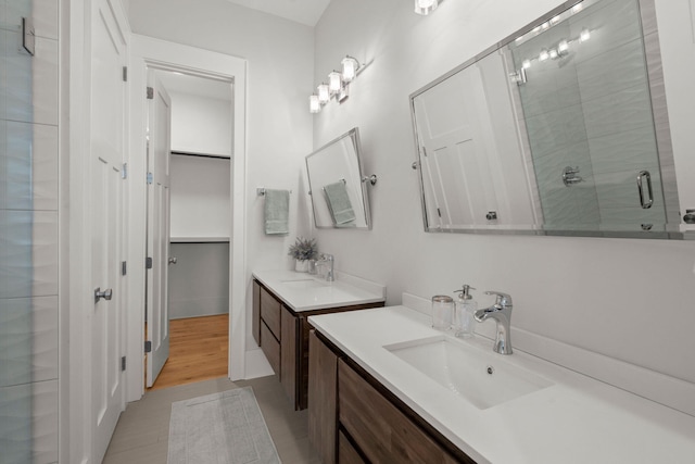 bathroom featuring a shower with shower door and vanity