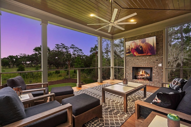 sunroom featuring an outdoor brick fireplace, a wealth of natural light, and wood ceiling