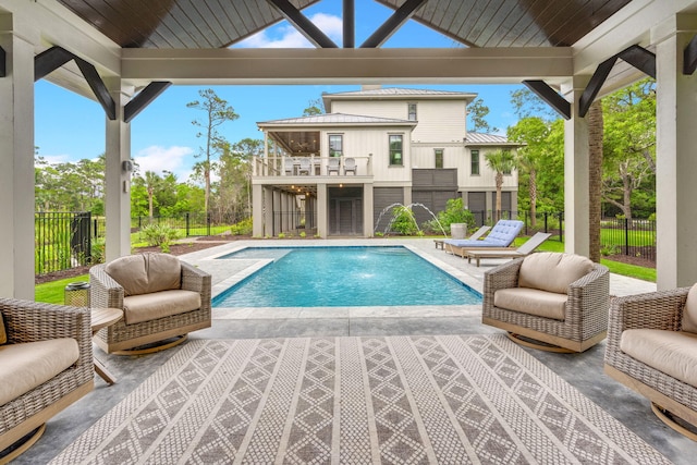 view of swimming pool with pool water feature, a patio area, and an outdoor living space