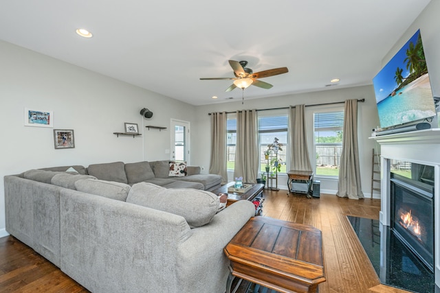 living room with ceiling fan and dark wood-type flooring