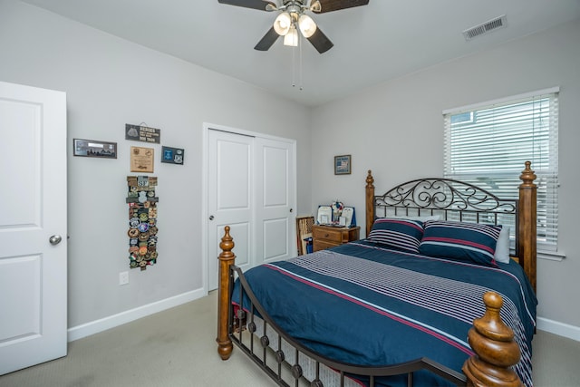 bedroom with ceiling fan, light colored carpet, and a closet