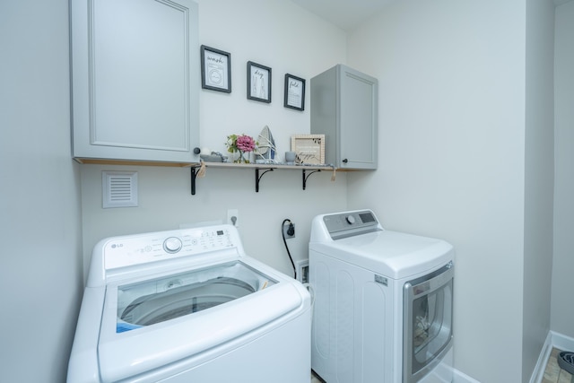 513 Abigail St, Moncks Corner, SC 29461 - clothes washing area featuring baseboards, washing machine and dryer, and cabinet space