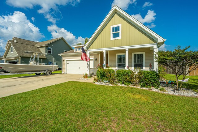 craftsman-style home featuring covered porch, a front yard, and a garage