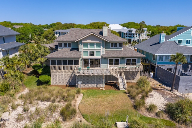 rear view of property featuring a wooden deck and a yard