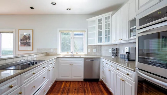 kitchen with backsplash, stainless steel appliances, dark hardwood / wood-style floors, sink, and white cabinets