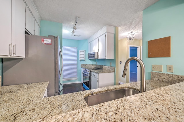 1115 Shadow Lake Cir, Mount Pleasant, SC 29464 - kitchen featuring appliances with stainless steel finishes, a sink, white cabinetry, light stone counters, and a textured ceiling