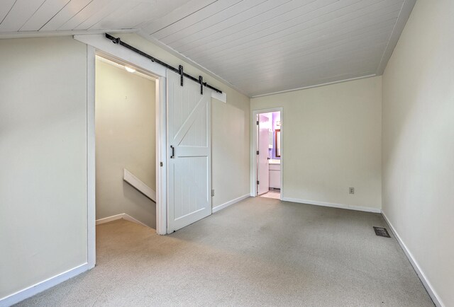 1115 Shadow Lake Cir, Mount Pleasant, SC 29464 - unfurnished bedroom featuring a barn door, carpet, baseboards, wood ceiling, and vaulted ceiling
