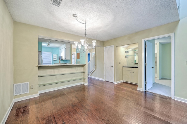 1115 Shadow Lake Cir, Mount Pleasant, SC 29464 - unfurnished dining area featuring a chandelier, a textured ceiling, wood finished floors, baseboards, and stairs