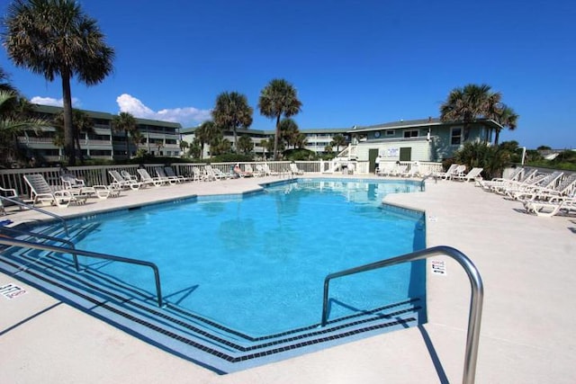 community pool with fence and a patio