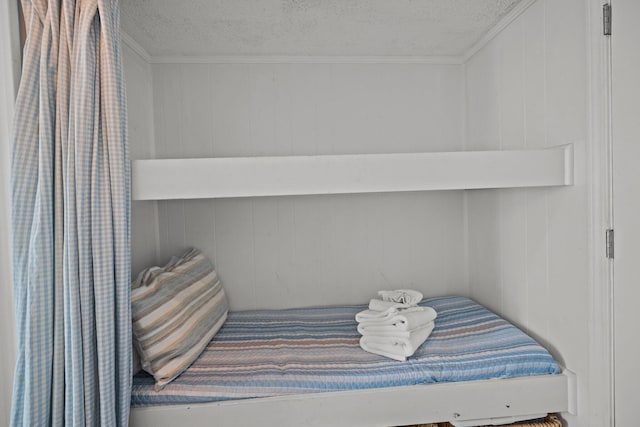 bedroom with crown molding and a textured ceiling