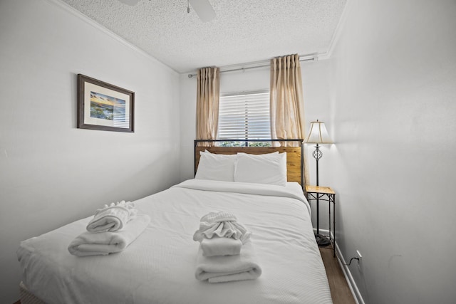 bedroom with crown molding, a textured ceiling, ceiling fan, and wood finished floors