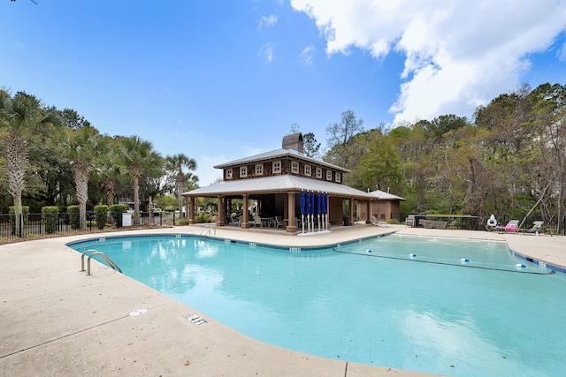 community pool featuring fence, a gazebo, and a patio