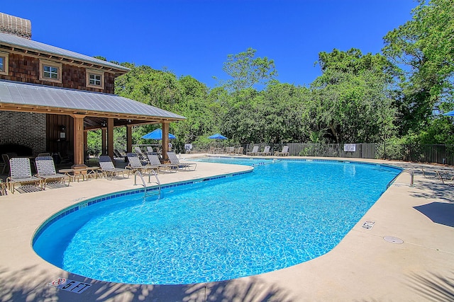 community pool with fence and a patio